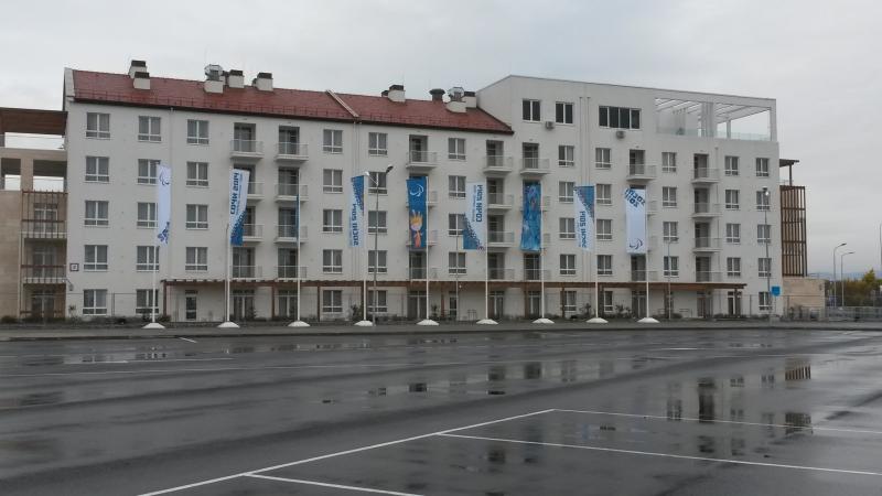 The coastal cluster Paralympic village wit flags in front of the buildings