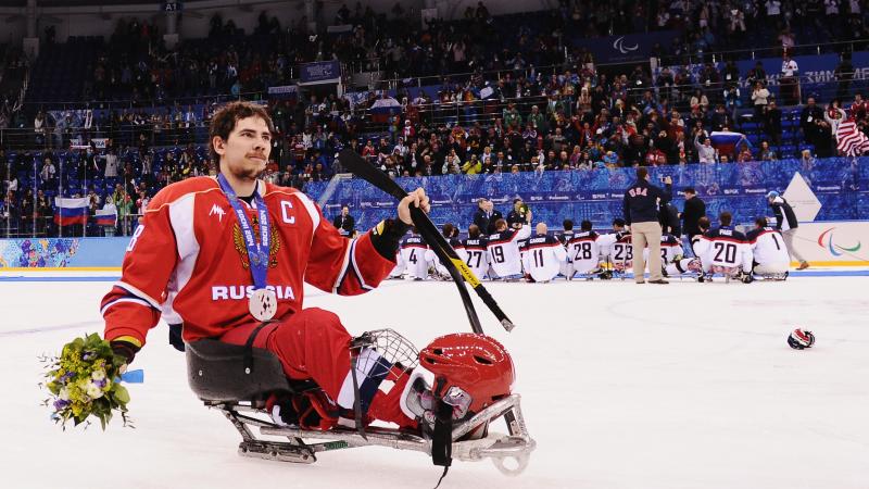 Russian ice sledge hockey player Dmitry Lisov takes his silver medal in stride on the ice at the Sochi 2014 Paralympics.