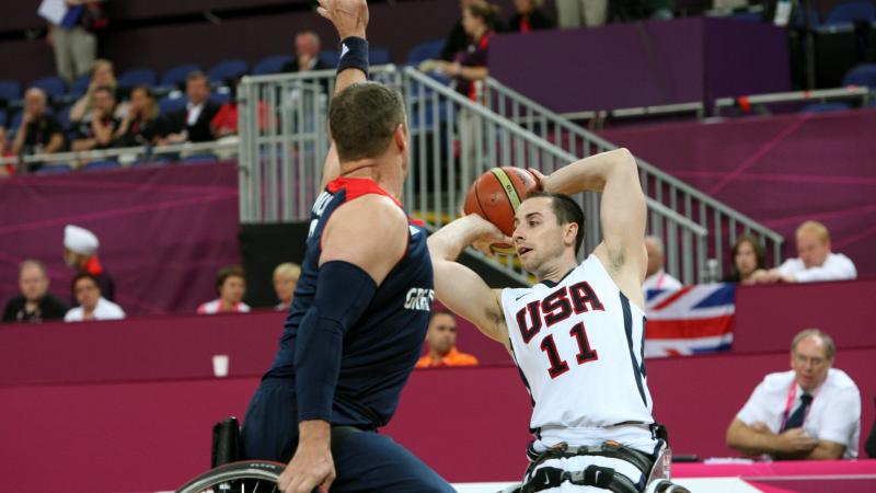 American wheelchair basketball player Steve Serio looks to pass the ball to a teammate.