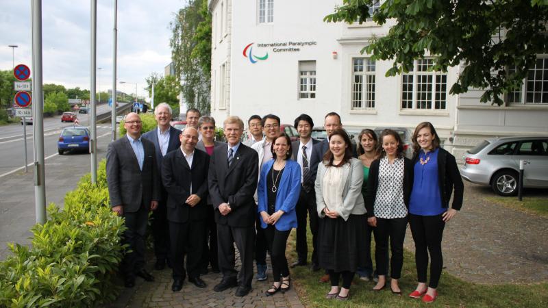 A group of people pose for a photo in front of the IPC headquarters building.