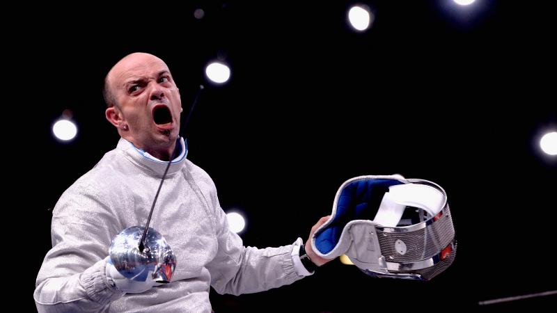 A wheelchair fencer celebrates after a victory.