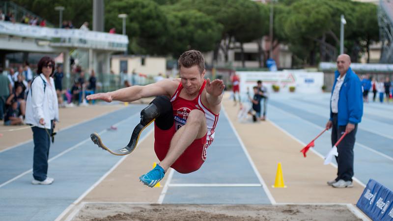 Markus Rehm, single leg amputee extends his legs over the long jump pit