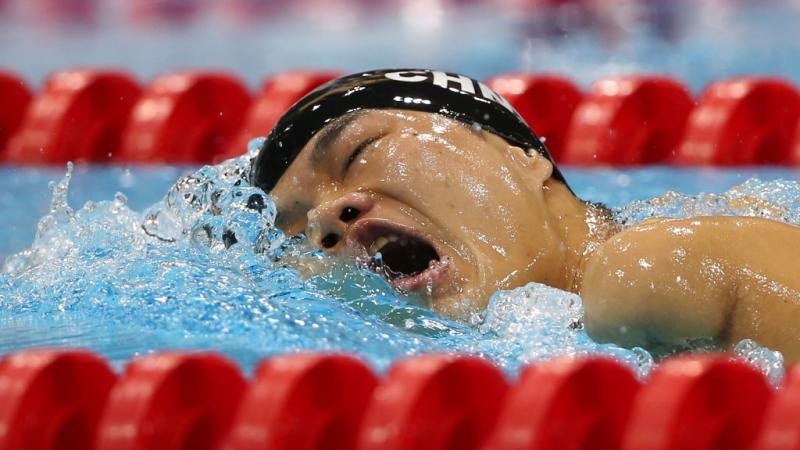 Swimmer in the water breathing between two freestyle strokes