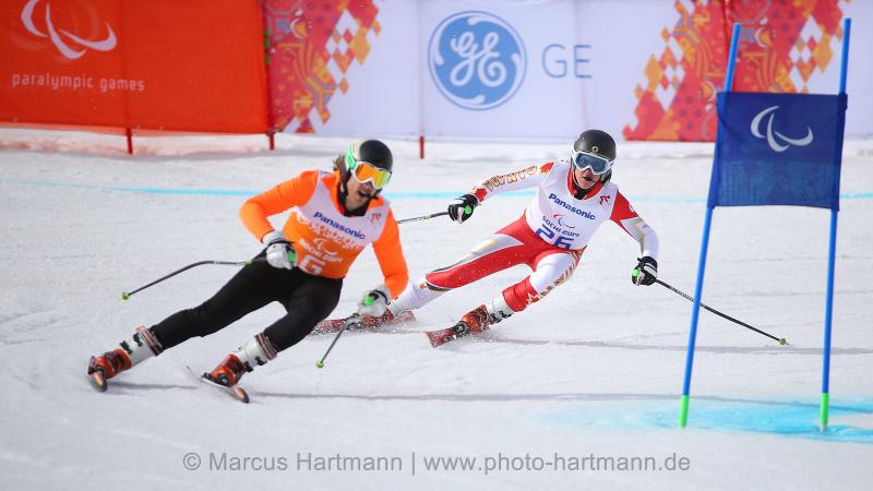 Two skiers behind each other on the slope