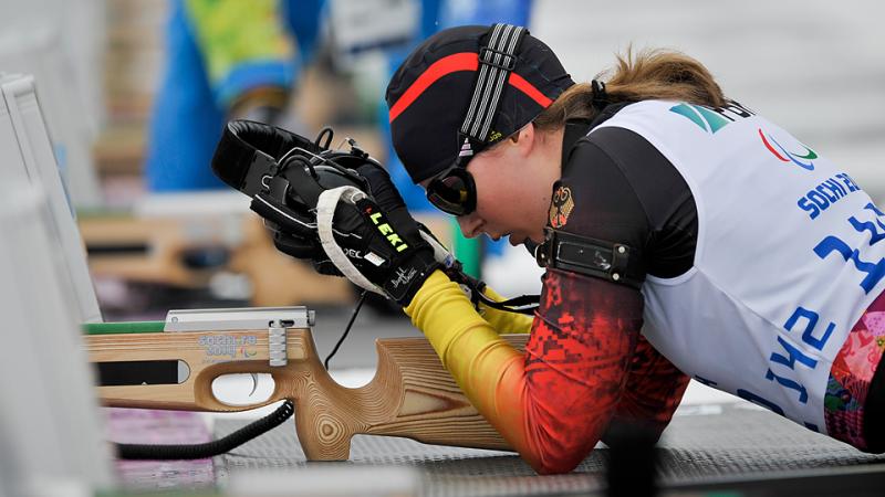 Visually impaired Vivian Hoesch, Germany places on her headphones and prepares to shoot in biathlon.