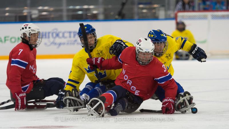 NOR vs. SWE Norweigen player Rolf Einar Pedersen defends puck against two Sweedish players