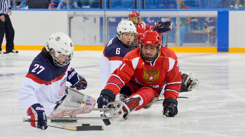 Evgeny Petrov tries to steal puck off Joshua Pauls