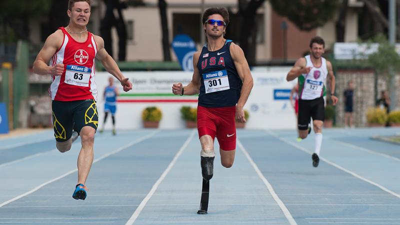 Three sprinters run on a blue track