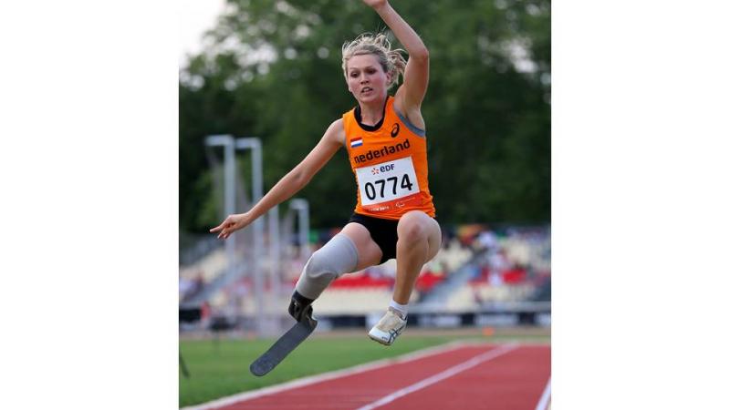 Blod women in orange jersey performing a long jump