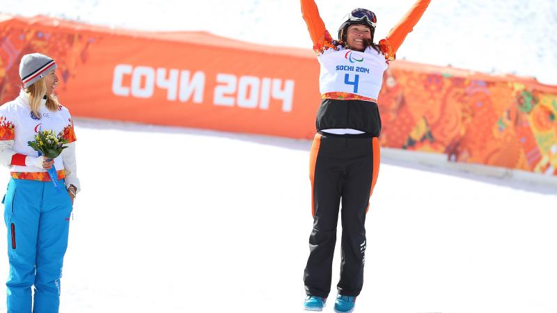 Bibian Mentel-Spee holds her arms high on the podium at the flower ceremony