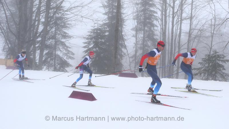 Four people do cross-country skiing on slopes
