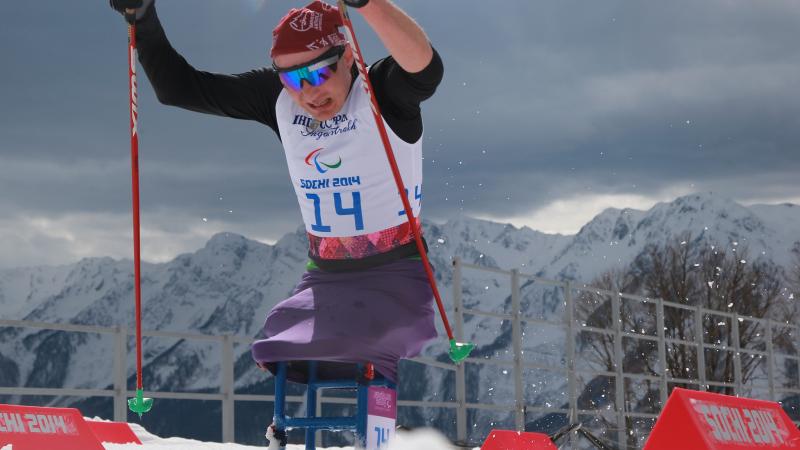 a Para Nordic skier pushes up the hill