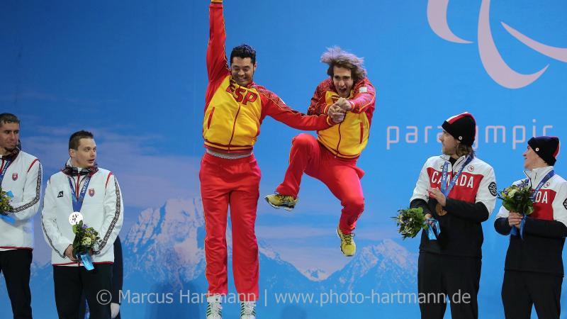 Two men jumping on the podium