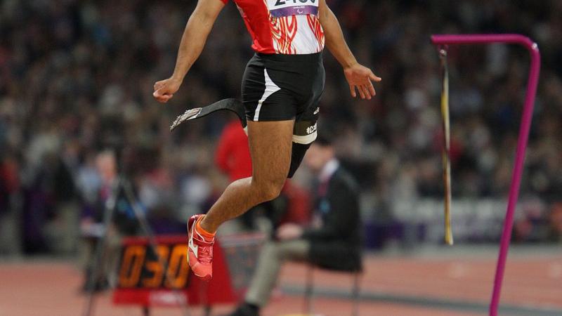 Man with prosthetic leg jumping in a stadium