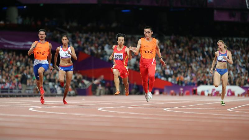 Female runners with guides on a track running