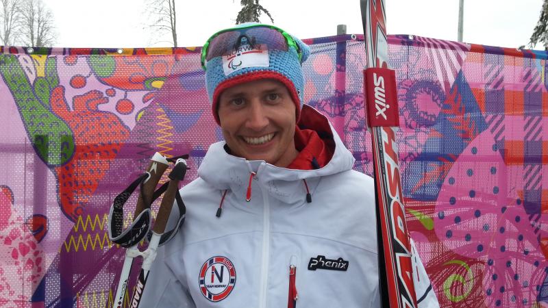 Nils-Erik Ulset Young man holding cross-country skies smiling to the camera