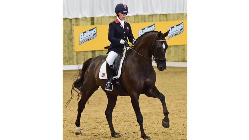 Women on a dark horse doing dressage lessons