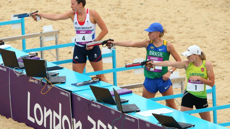 Women in a shooting range with the branding "London 2012"