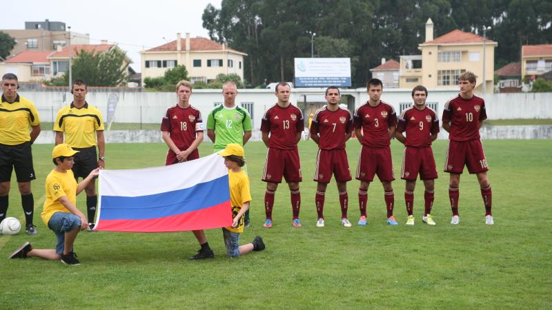 7 Russian players standing next to each other singing the national anthem during the 2014 CPISRA Football 7-a-side European Championships.