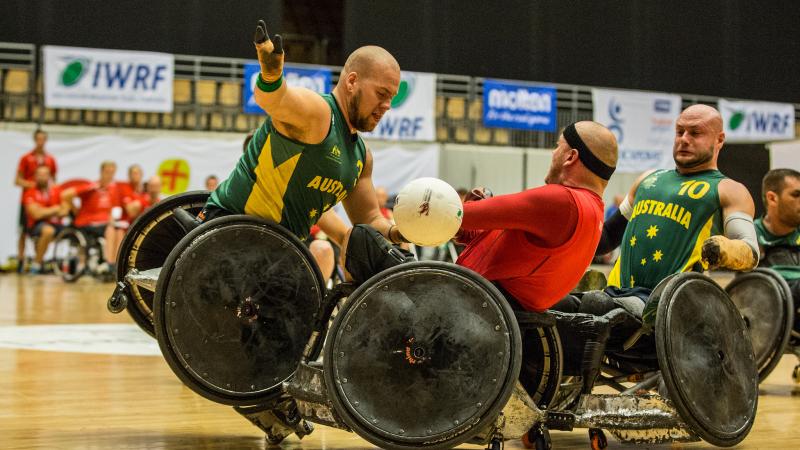 Ryley Batt - 2014 IWRF World Championships A Danish player wearing red loses control of the white ball as he is sandwiched between two Australian players wearing green.