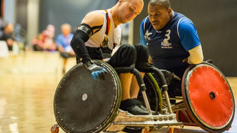 A French player wearing blue collides with his German opponent during a wheelchair rugby game.