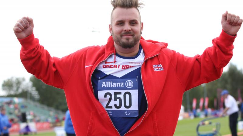 Man celebrating, wearing a red jacket