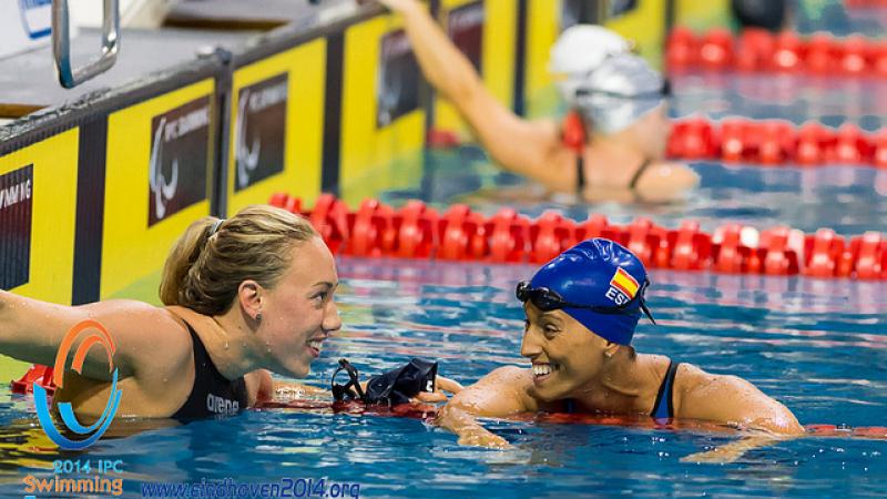 Two swimmers smile at each other after competing at the 2014 IPC Swimming European Championships