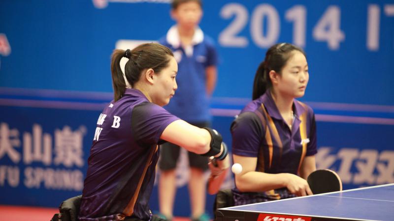 two female Chinese para table tennis players playing doubles