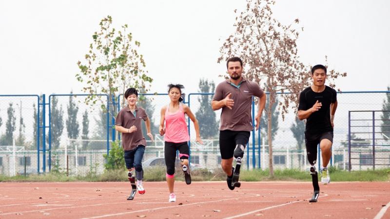 Four people with prothesis sprinting