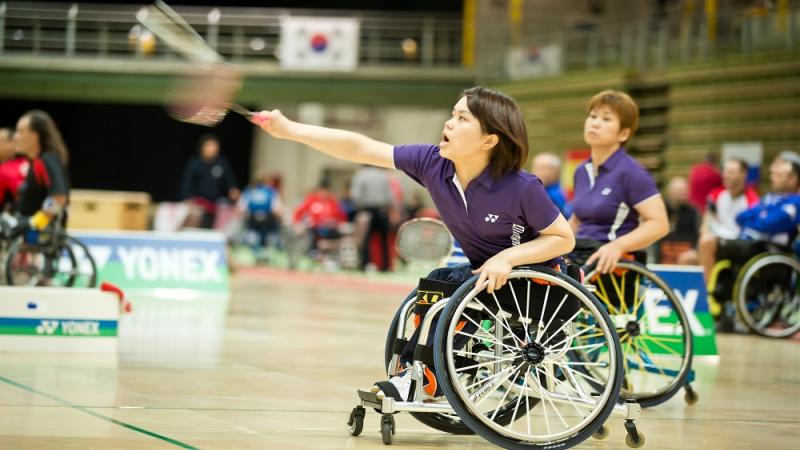 Two women in action during a para-badminton doubles match
