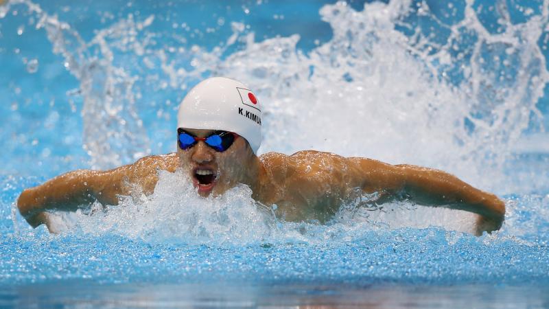 Swimmer in butterfly style in a pool with a simming cap