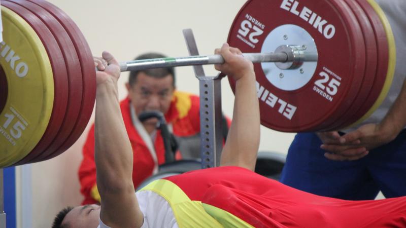 Powerlifter on a bench lifting a bar