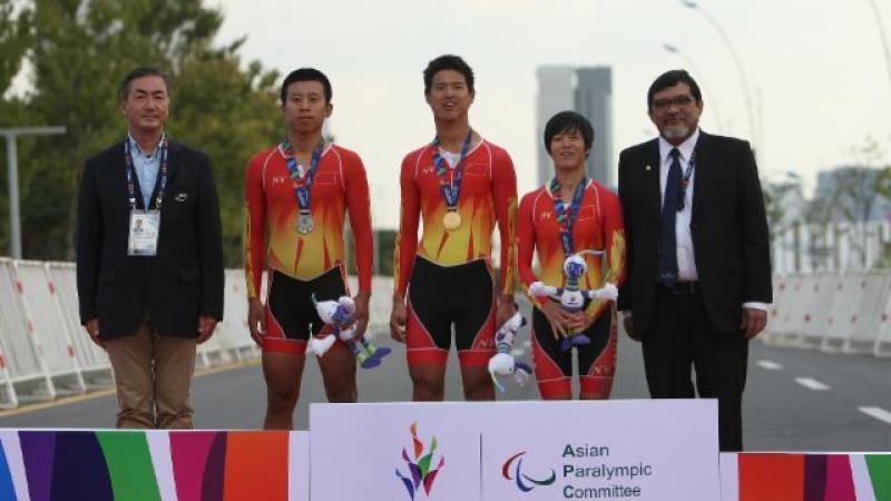 Three Chinese athletes standing on the podium