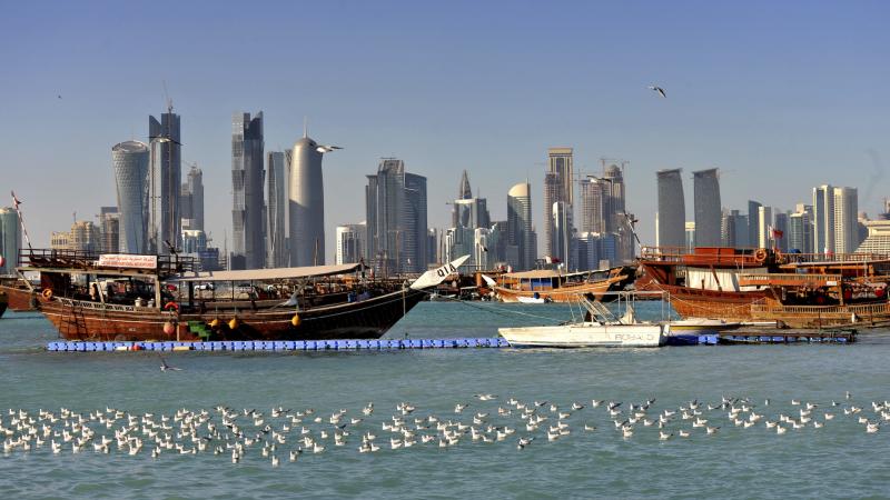 Wooden boat in the water, skyscrapers in the background