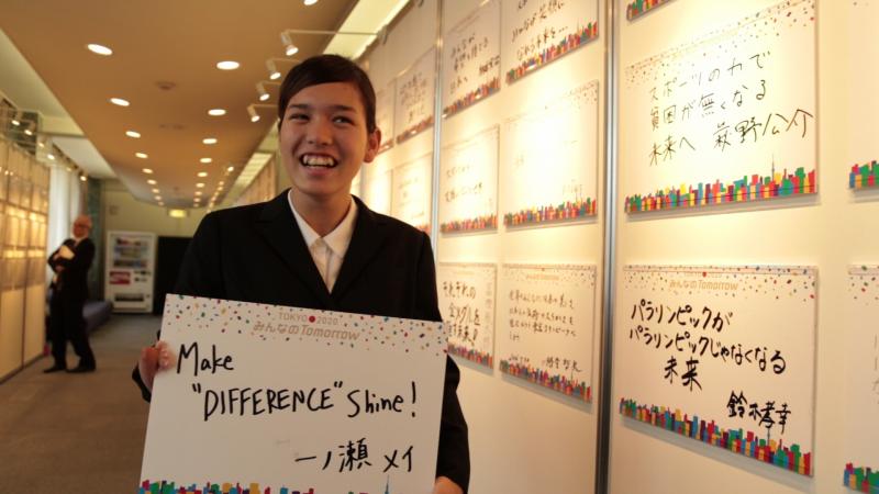 Japanese swimmer Mei Ichinose holds a sign where it is written "Make difference shine"