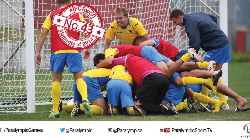 Players celebrate, jumping one on another on a football field of play