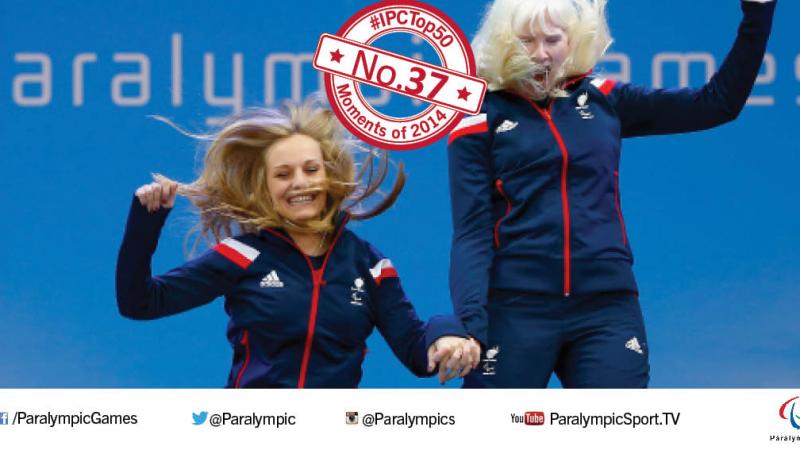 Two women make a jump of joy on a podium