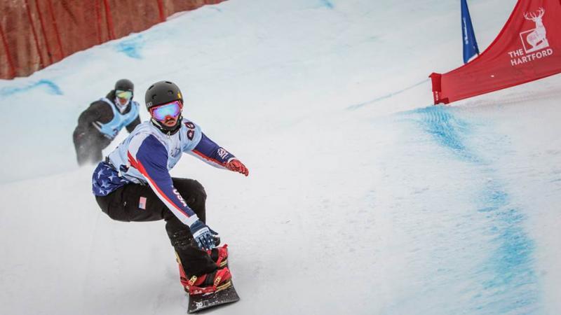 Two snowboarders race on a slope