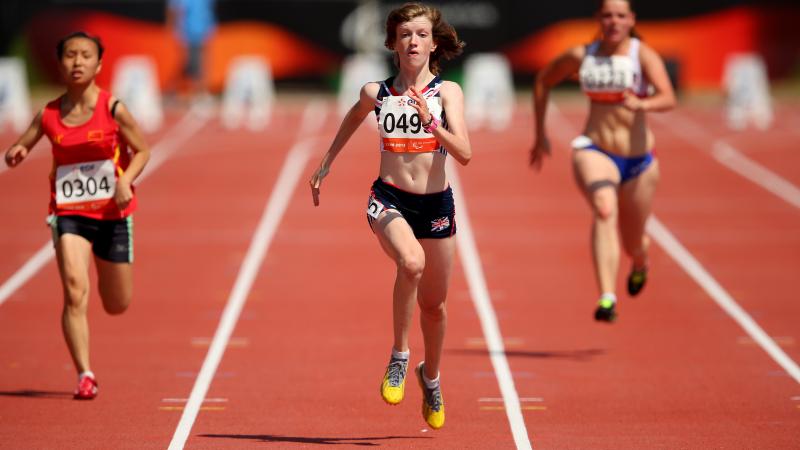 Women run on the finish line of a stadium