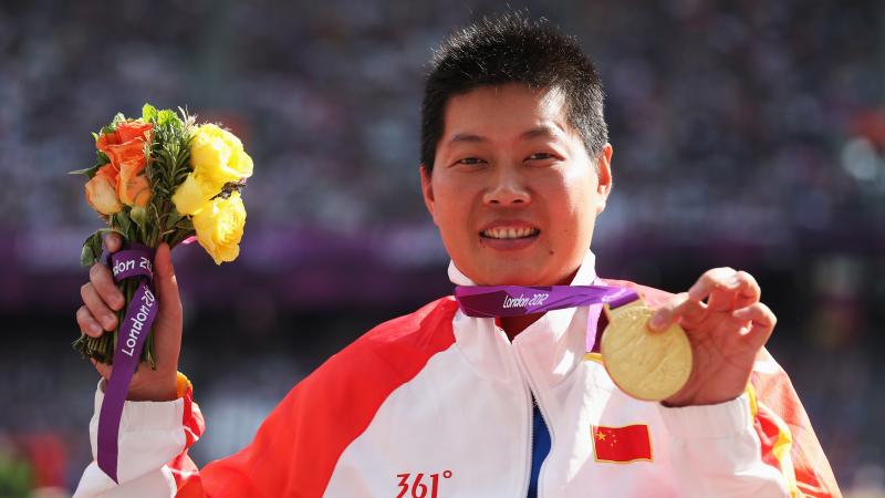 Portrait shot of women showing her medal to the camera.