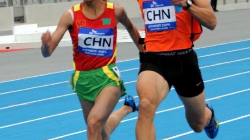 Blindfolded women with guide running in a relay