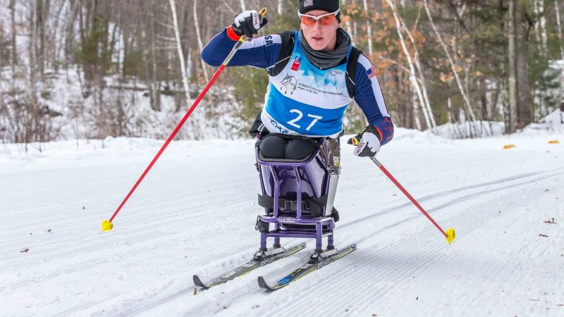 Women in sit ski on snow