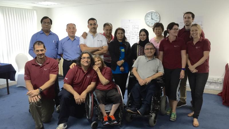 Group picture of people standing sitting and sitting in wheelchairs