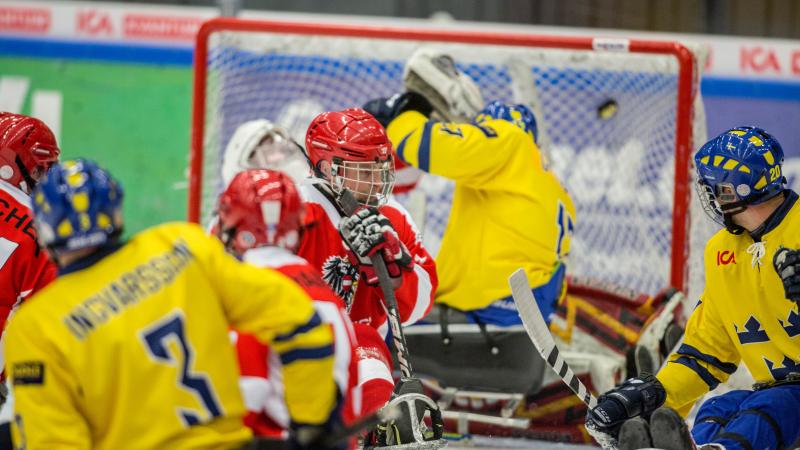 Five ice sledge hockey players on the field during a game