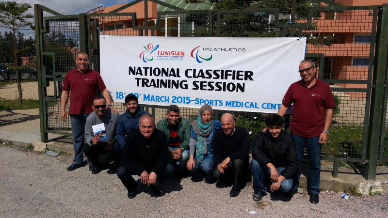 A group of people pose in front of an IPC Athletics banners in Tunis, Tunisia.