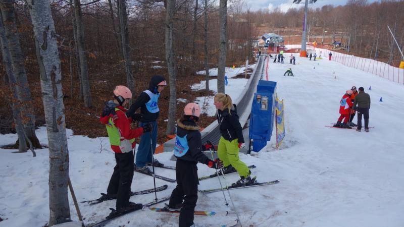 A group of youngsters are taught how to ski