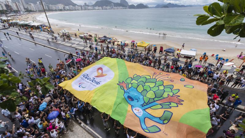 Crowd of people from above, holding a huge banner with Rio motives