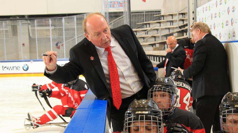 Ice sledge hockey coach talking to his players.