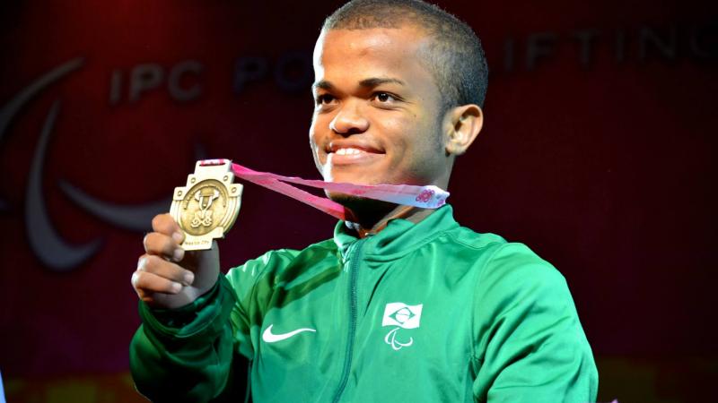 Man smiling, showing his medal