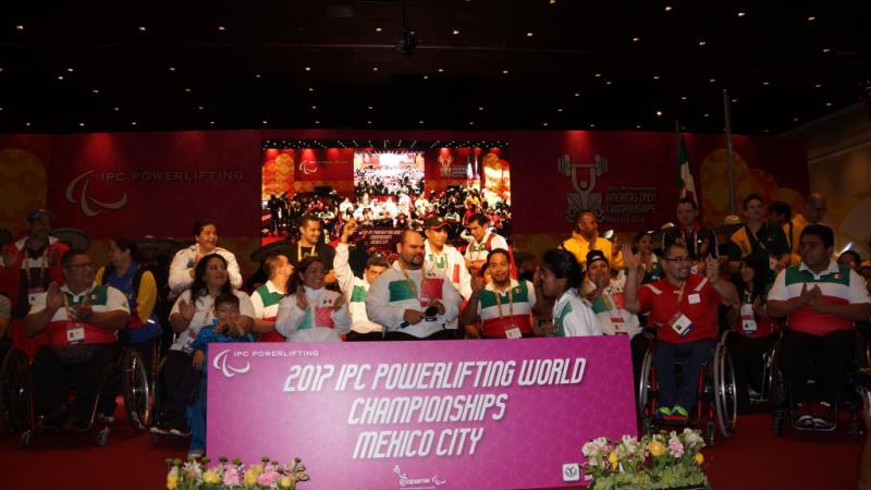 Group shot on a stage with a big sign in front